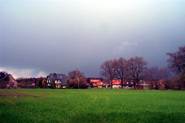 Blick ber eine groe Wiese auf eine Wohnsiedlung