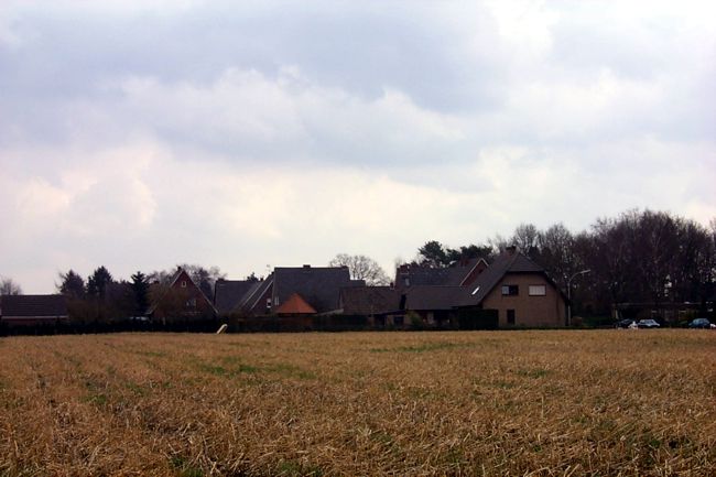 Blick ber Felder auf eine Wohnsiedlung