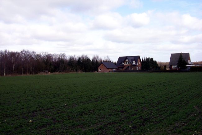 Blick ber ein Feld auf ein hbsches Haus