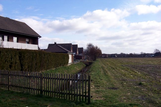 Ein Wassergraben am Rand der Siedlung