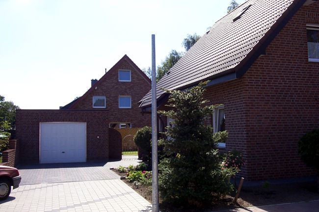 Neben der Garage erkennt man ein eisernes Gartentor