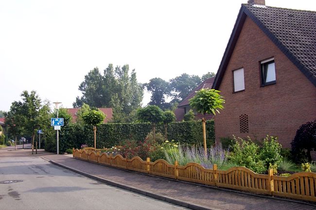 Ein hbscher Holzzaun umrandet den schn gestalteten Garten