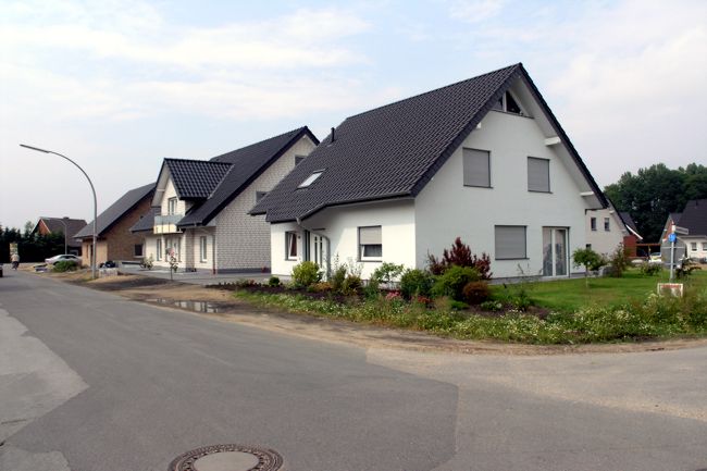 Ein hbsches Haus mit einen schn gestalteten Beet und Garten