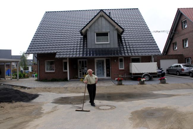 Ein Anwohner posiert vor einem hbschen Doppelhaus