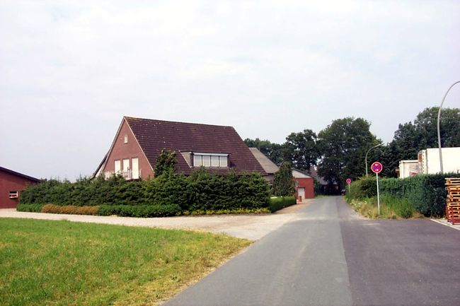 Eine hohe Hecke vor dem Wohnhaus des Bauernhofs