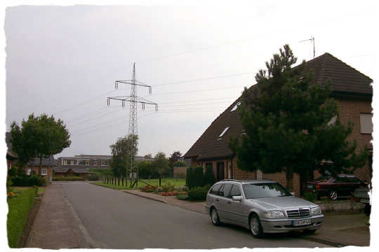 Ein Hochspannungsmast mitten in der Siedlung