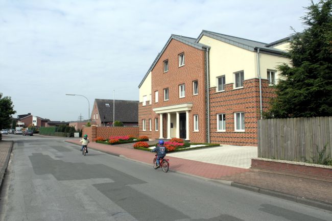 Vor dem Haus sind sehr gepflegte, farbenfrohe Beete zu erkennen
