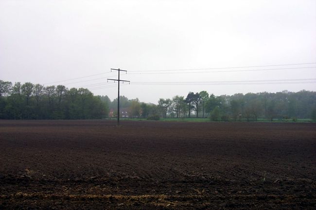 Der Mast einer berlandleitung mitten in einem Feld